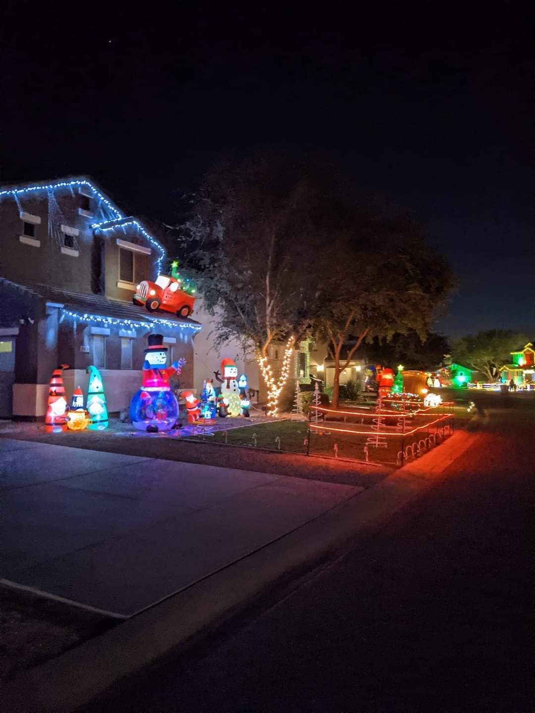 A Pecan Creek South home covered in lights, gnomes, and a vintage truck on the roof